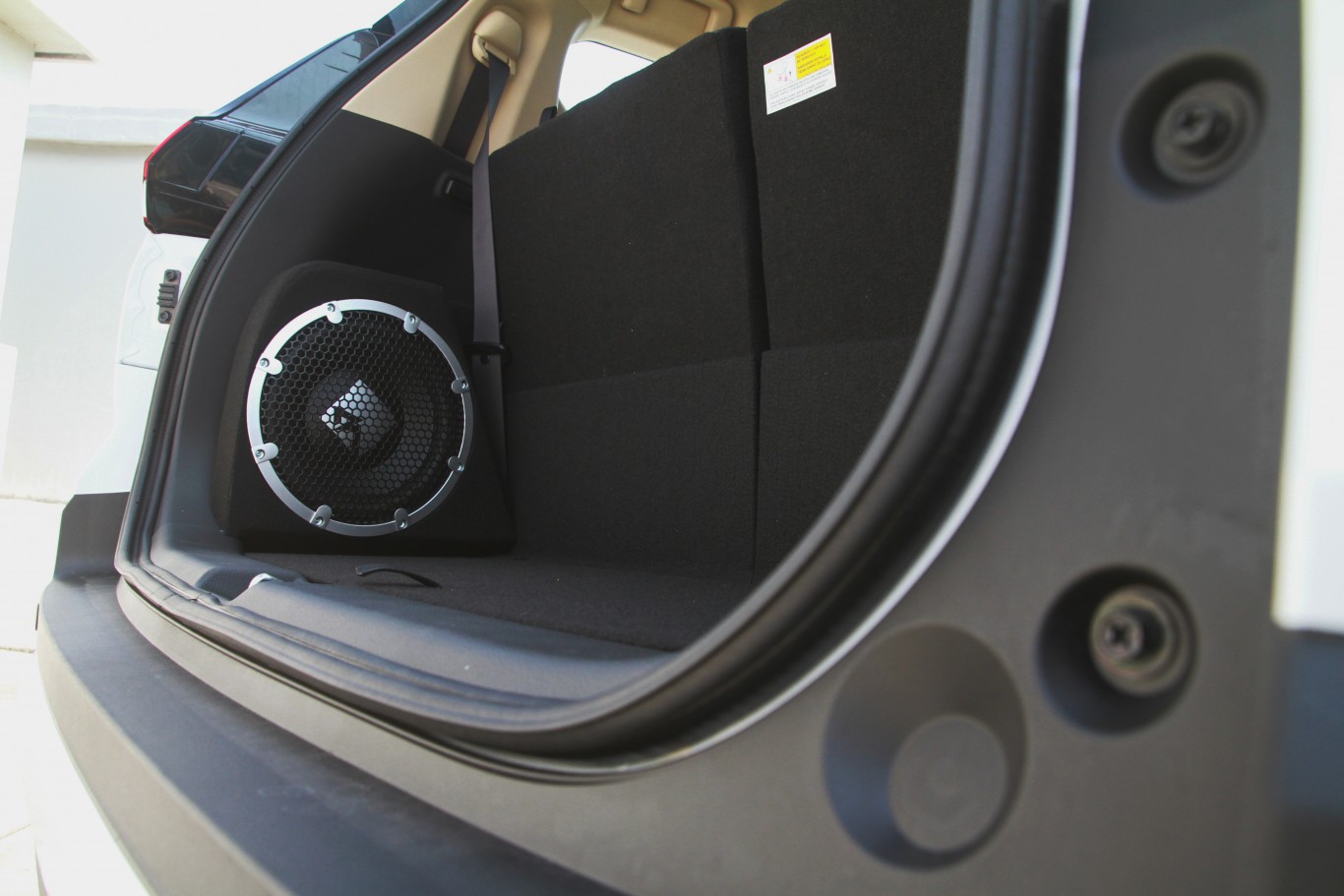 Vehicle trunk with an integrated aftermarket subwoofer system